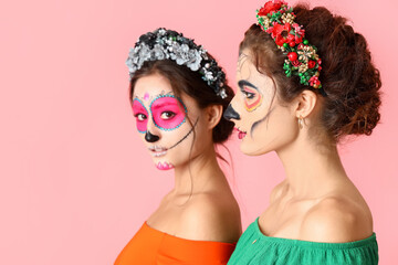 Obraz premium Stylish women with painted skull on faces against color background. Celebration of Mexico's Day of the Dead (El Dia de Muertos)