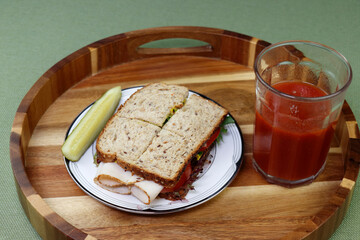 Turkey Sandwich with a Pickle and Tomato Vegetable Juice