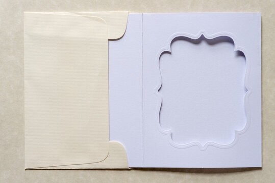 plain die cut paper card with fancy window opening inside an envelope