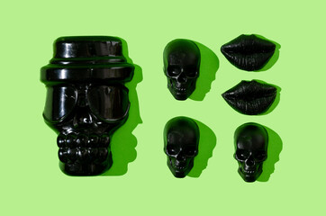 An infographic or pattern or wallpaper made of black sculls and black lips on neon green backgropund. Halloween party invitation concept.