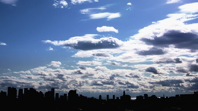 City Skyline with blue sky covered over with heavy clouds in a time lapse sequence