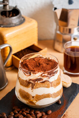 Tiramisu espresso coffee ladyfinger Italian traditional food sweet dessert homemade bakery in glass with beans short grinder