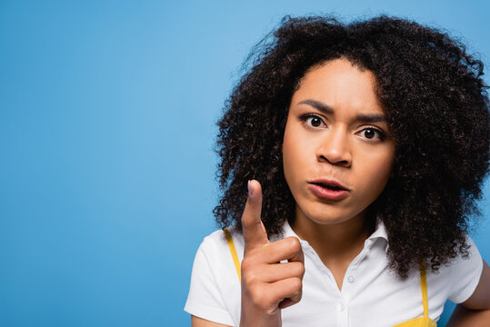 angry african american woman looking at camera and pointing with finger isolated on blue