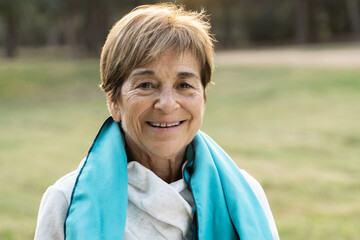 Portrait of senior woman smiling on camera after workout sport session outdoor at city park - Focus...