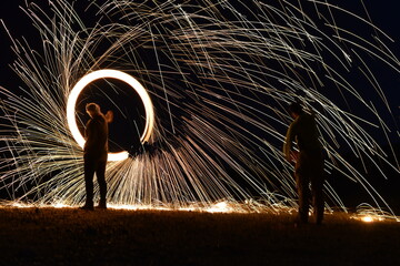 Iron wool circle drawing light fireworks. Burning Steel Wool spinning, Trajectories of burning sparks at night. Movement light effect, steel wool fire hoop. long exposure light painting, Pyrotechnic
