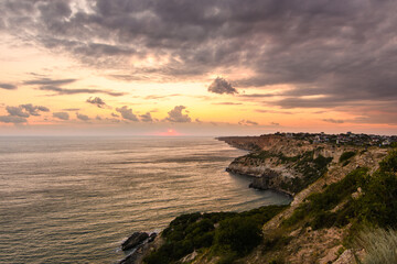 Fototapeta na wymiar Beautiful sea sunset and rocky coast. Dramatic sky with clouds. Crimea.