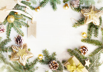 A Christmas flatlay  with Christmas tree branches, cones, a gift bag and decorations. On a white wooden background , copy space , mock up