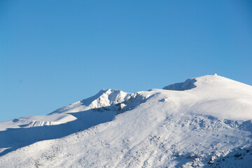 Fototapeta na wymiar Snow-capped mountain peaks on a sunny day. background for winter sports and winter holidays