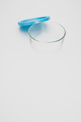 Vertical shot of a glass decanter and its blue cap on the white background