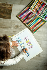 girl coloring merry christmas letters