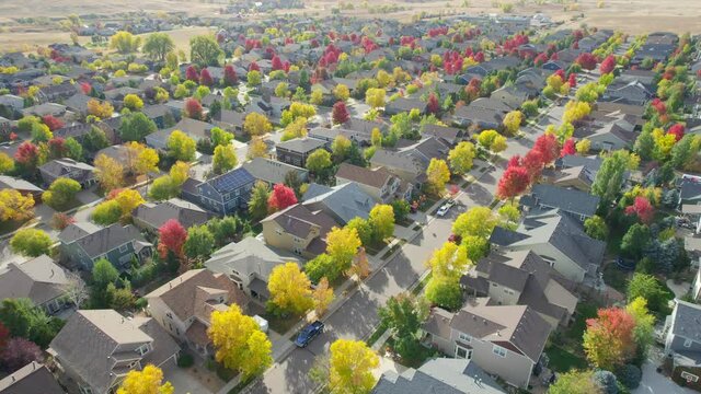 Aerial drone flyover of rows of houses lining streets in middle class neighborhood in Colorado