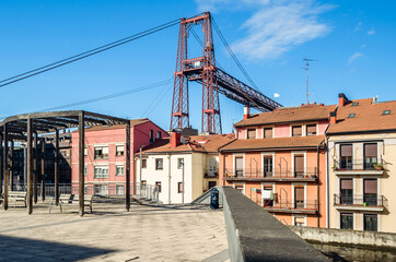 Obraz premium Colorful facades in Portugalete old town, with the famous Vizcaya Bridge in the background