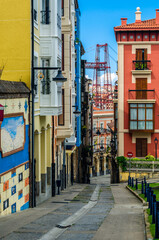 Fototapeta na wymiar Colorful facades in Portugalete old town, with the famous Vizcaya Bridge in the background