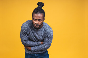 Young african american black man with afro hair isolated over yellow background with hand on...