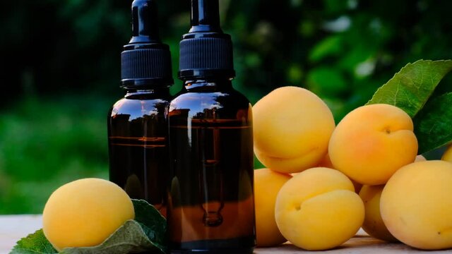 Apricot kernel oil. Organic natural bio oil. Apricot oil in a glass bottle with a pipette and ripe apricots fruits.4k footage