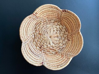 Handmade flower shape basket made from dried water hyacinth, woven basket for home use and decoration, weaved basket on black background