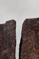 weathered batholith granite rock formation where erosion resulted in a gap dividing the rock in front of overcast sky - obrazy, fototapety, plakaty