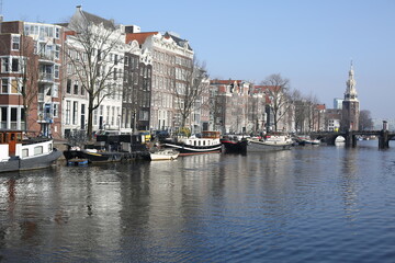 cityscape of traditional brick houses and canal of winter amsterdam