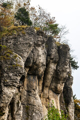 The Röthelfels with trees in bright autumn colors and further rocks at Gößweinstein, Franconian Switzerland, Germany