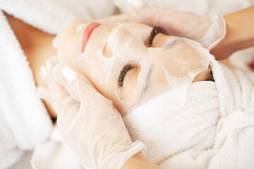 Obraz na płótnie Canvas Woman with cotton face mask in beauty salon