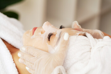 Obraz na płótnie Canvas Woman with cotton face mask in beauty salon