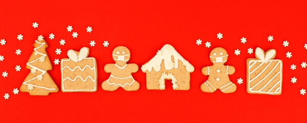 Happy New Year's 2022 set of gingerbread man in face mask from ginger biscuits glazed sugar icing decoration on classic traditional red background, minimal seasonal pandemic winter holiday banner
