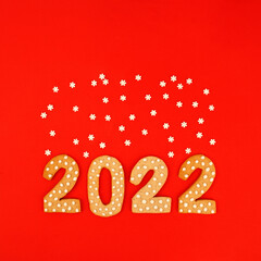 Happy New Year 2022. Christmas, winter holidays concept. Gingerbread cookies Number and snowflake set confetti on traditional red background, fleyer, invitation, greeting card, banner