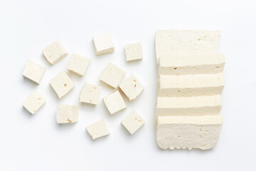 A sliced pieces and cubes of tofu on white background close-up.