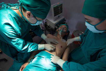 Two Asian surgeons working together on a surgery in operation room.