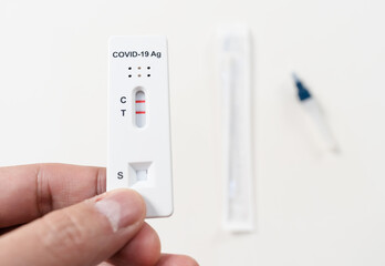 hand with Coronavirus(Covid-19) positive test result with SARS-CoV-2 Antigen Rapid Test kits for Self testing