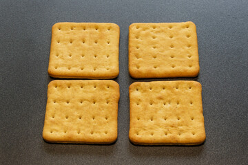 four golden crackers on a black background