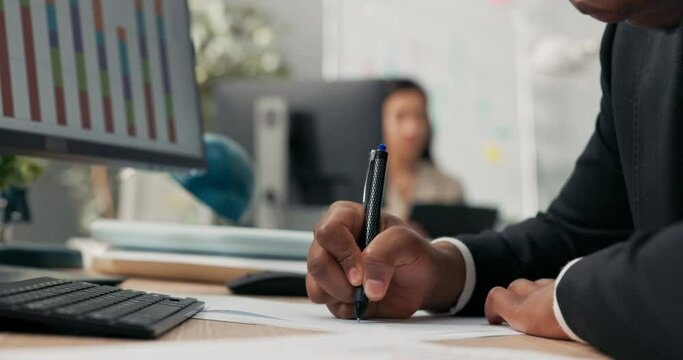 Close-up hand shot of dark-skinned man holding pen, signing documents, filling out application, cuffs of black suit, office scene, boss, manager, businessman gives consent, makes initial