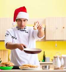 Young chef husband working in kitchen at Christmas eve