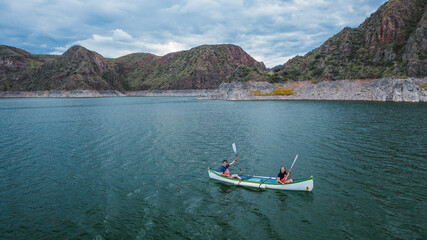 Young couple canoeing in a lake having fun.