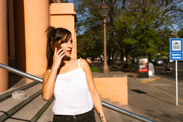 Medium shot of an attractive Latina woman talking on the cell phone. Technology, communications concept.