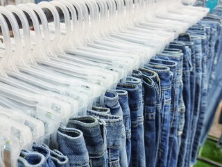 Fototapeta premium Second-hand clothes are neatly folded and hung at a market in Thailand. selection focus.