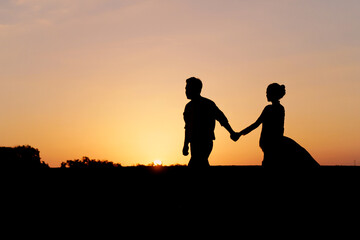 Fototapeta na wymiar silhouette of a romantic young couple on the beach