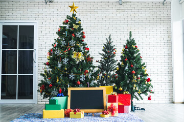 Christmas blackboard with many gifts with abstract green Christmas tree background with Copy Space,Decoration During Christmas and New Year.