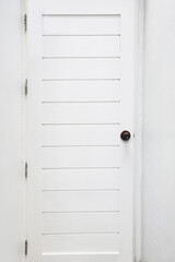 Close up of white wooden door on white wall for background