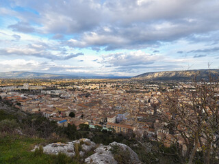 Fototapeta na wymiar Town of Cavaillon in the Vaucluse in Provence in France under a nice cloudy sky from the hill of Saint-Jacques which overlooks the town 