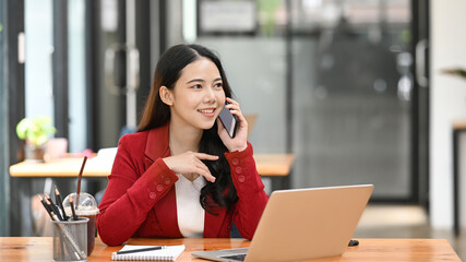 Obraz premium Successful businesswoman talking on smart phone with her business partner.