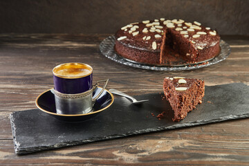 Autumn brownie pie with walnuts and chocolate. Cup of coffee on the background. French gourmet cuisine