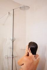 rear view. naked woman washes hair in the shower. the beauty of the female body