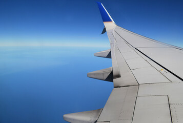 Fototapeta premium Aerial view of the ocean from a plane window with wing