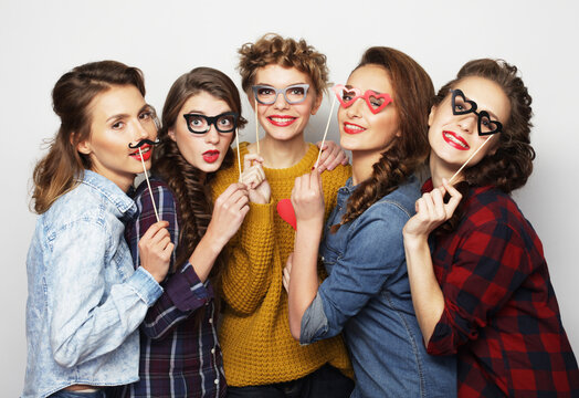 lifestyle, party, emotion and people concept: five stylish young women best friends holding party props,