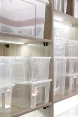 Plastic containers on a shelf for organizing home space, order and interior, sale of household goods