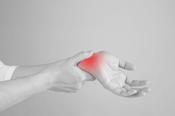 Woman's wrist hand get injure and hurt in inflaming. massage her wrist to relive pain.