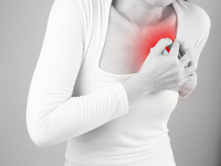 Women clutch chest heart attack symptom. A pain from heart stroke Healthcare and medical concept.