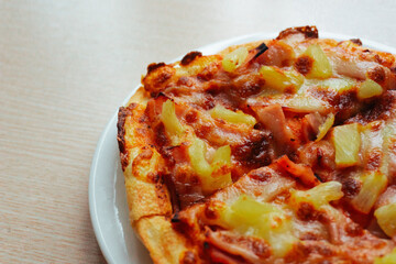 Close up of Pizza with pineapple,  mozzarella cheese, ham, bacon, pizza sauce. Sliced Hawaiian pizza texture, 