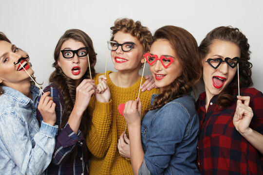 lifestyle, party, emotion and people concept: five stylish young women best friends holding party props,